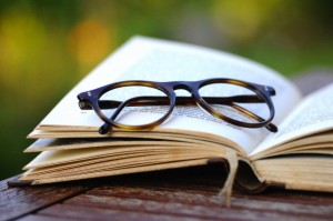 Old reading glasses with a book in the garden